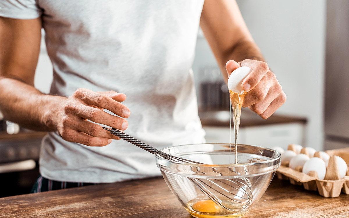 Close-up of man preparing omelette for breakfast