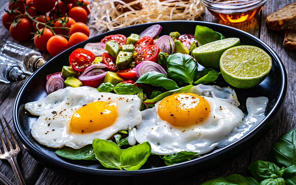 Sunny side up eggs with avocado, cherry tomatoes, toasted bread